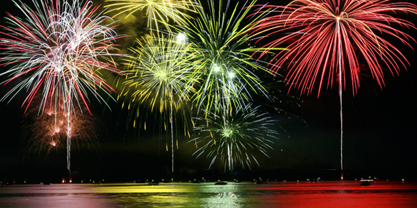 A View of the City Skyline and Colorful Crackers from the beach.