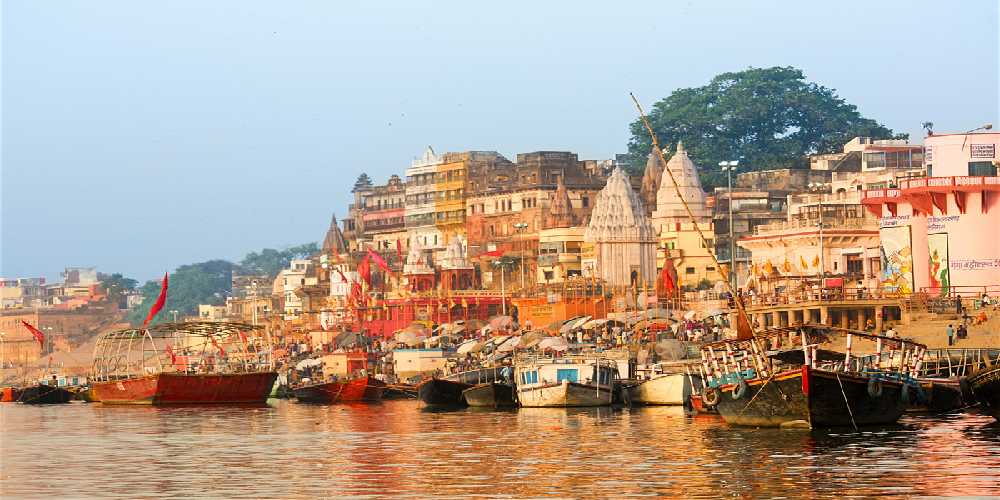 Flotilla Of Boats At The Ghats In Varanasi, Enhance The Ganges Riverfront With A Multitude Of Shrines, Temples, And Palaces. 